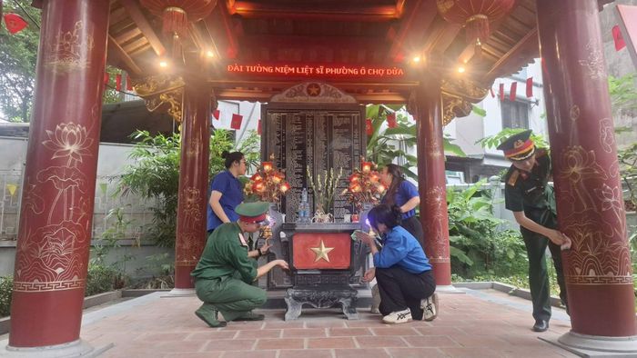 Đoàn viên, thanh niên phường Ô Chợ Dừa và cán bộ, chiến sĩ chỉnh trang khuôn viên nhà bia liệt sĩ tại chùa Cát Linh. Ảnh: VG.