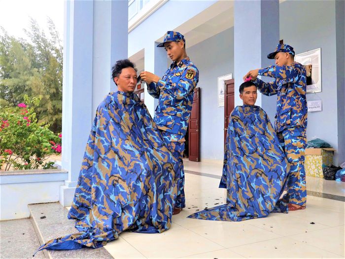 Cán bộ, chiến sĩ trên đảo cắt tóc cho ngư dân.