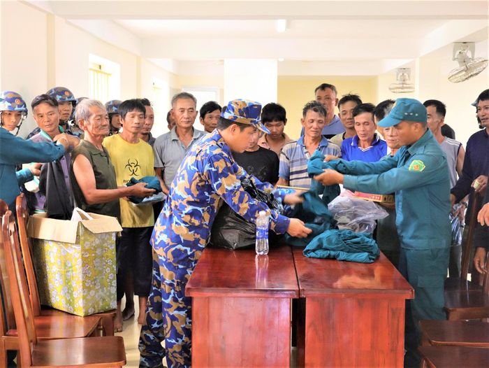 Cán bộ, chiến sĩ, Tiểu đội dân quân và các lực lượng trên đảo cấp phát quần áo, nhu yếu phẩm cho ngư dân.