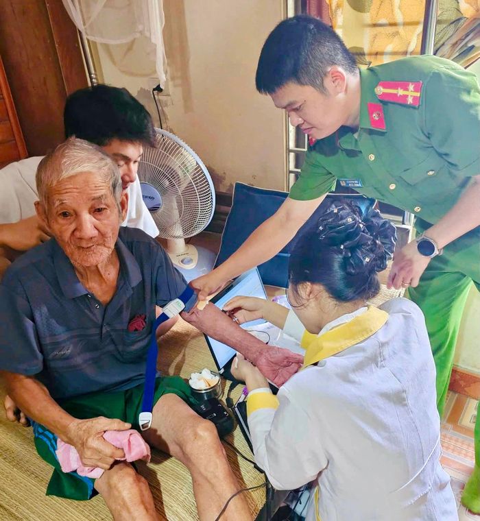 Cán bộ Công an đến tận nhà thu nhận mẫu ADN của thân nhân liệt sĩ. Ảnh: H.Phong
