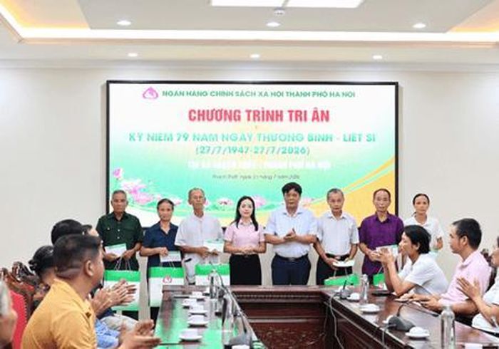 Phó Giám đốc, Chủ tịch Công đoàn cơ sở NHCSXH thành phố Hà Nội Ngô Thúy Hằng trao quà cho các gia đình chính sách tại xã Thạch Thất