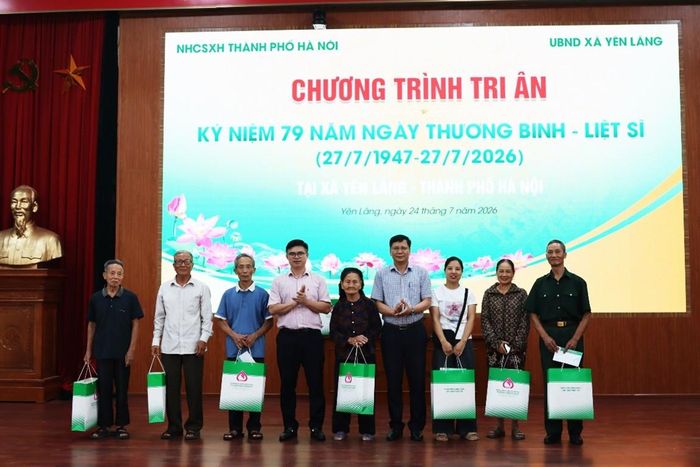 Phó Giám đốc NHCSXH thành phố Hà Nội Đặng Đức Hạnh và Phó Chủ tịch HĐND xã Yên Lãng Phạm Thành Đô trao quà cho các gia đình người có công