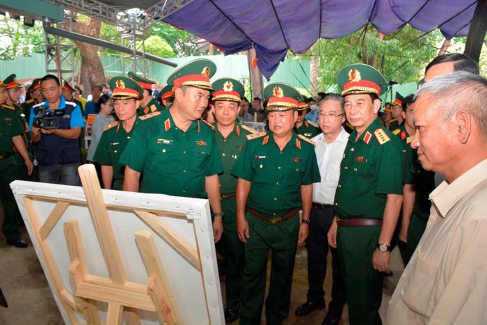 Phó Thủ tướng Chính phủ, Bộ trưởng Bộ Quốc phòng Phan Văn Giang cùng các đại biểu tại khu vực trưng bày các hình ảnh hoạt động tìm kiếm, quy tập hài cốt liệt sĩ ở Công viên Lê Thị Riêng.