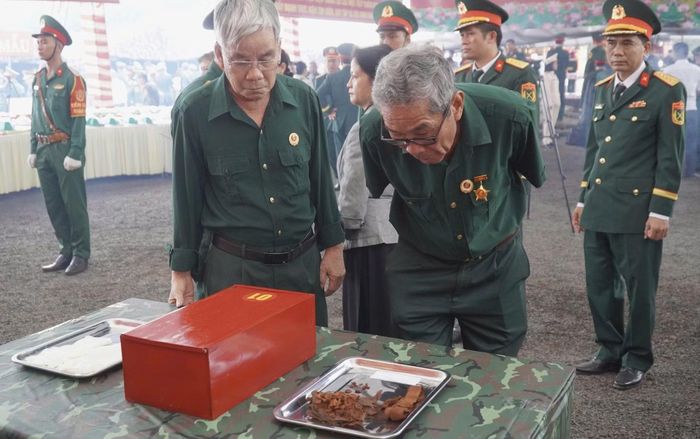 Các cựu chiến binh xem lại di vật của đồng đội tại buổi lễ.