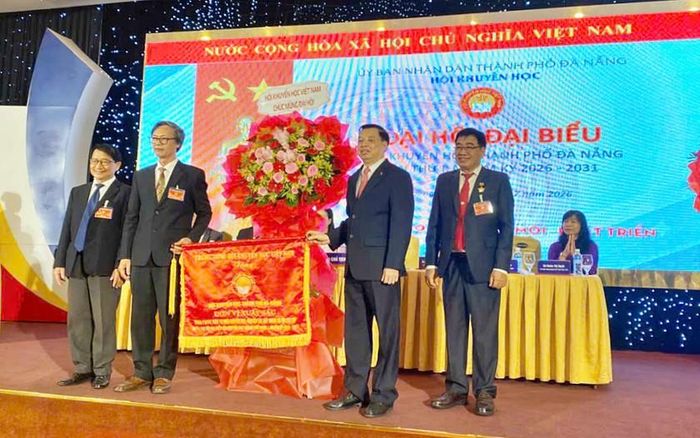 Phó Chủ tịch kiêm Tổng Thư ký Trung ương Hội Khuyến học Việt Nam trao Cờ thi đua xuất sắc nhiệm kỳ 2022-2026 của Hội Khuyến học Việt Nam tặng Hội Khuyến học thành phố Đà Nẵng. 