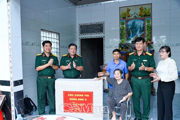  Đại tá Lê Hoàng Giữ, Phó Chủ nhiệm Chính trị Quân khu 9 và Đại tá Lê Quang Luật, Phó Chính ủy Bộ Chỉ huy Quân sự tỉnh Cà Mau, trao quà chúc mừng gia đình bà Phạm Thị Buội có nhà mới. 