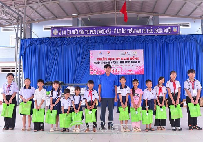Anh Nguyễn Đinh Lăng, Phó Chánh Văn phòng HĐND, UBND Xã Hồ Thị Kỷ, đại diện mạnh thường quân, trao sách giáo khoa, dụng cụ học tập cho học sinh.