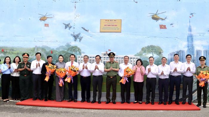 Các đại biểu chụp hình lưu niệm bên công trình bích họa
