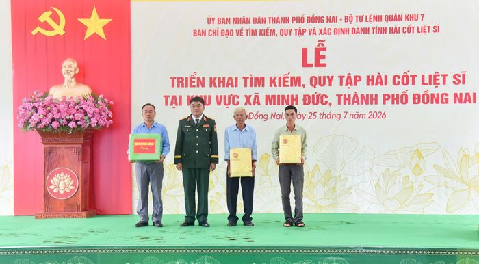 Lực lượng trực tiếp thực hiện nhiệm vụ, các nhân chứng lịch sử và người cung cấp thông tin tìm kiếm, quy tập hài cốt liệt sĩ ở xã Minh Đức được tặng quà từ cơ quan chức năng. (Ảnh: Lương Ý) 