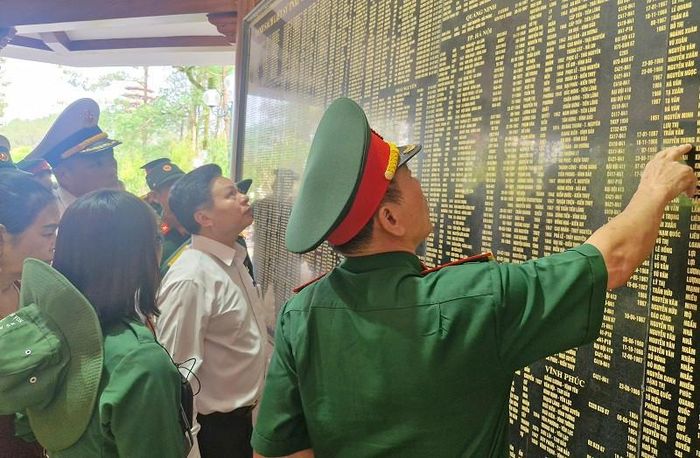 Đoàn khách tham quan tại Nhà bia tưởng niệm liệt sĩ thanh niên xung phong toàn quốc ở Ngã ba Đồng Lộc. Ảnh: PV