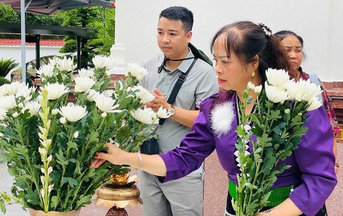 Người dân kính cẩn dâng hoa tại khu mộ 10 nữ anh hùng liệt sĩ thanh niên xung phong nơi Ngã ba Đồng Lộc. Ảnh: PV