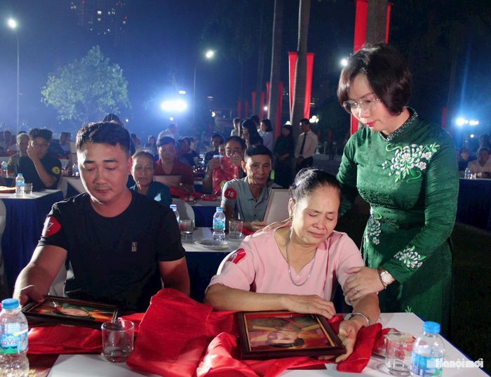Ủy viên Ban Thường vụ Thành ủy, Chủ tịch Ủy ban MTTQ Việt Nam thành phố Hà Nội Bùi Huyền Mai trao di ảnh được phục dựng và động viên thân nhân liệt sĩ. Ảnh: Lê Phương.