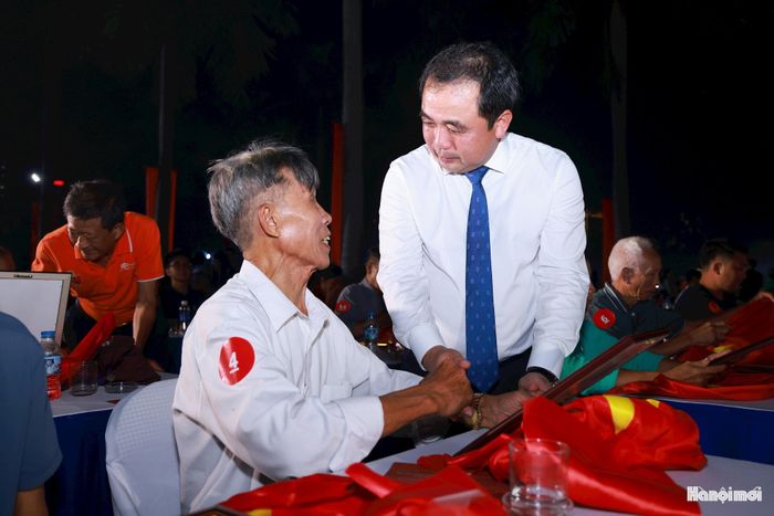Ủy viên Bộ Chính trị, Bí thư Thành ủy, Trưởng đoàn đại biểu Quốc hội thành phố Hà Nội Trần Đức Thắng trao di ảnh được phục dựng, động viên thân nhân liệt sĩ. Ảnh: Văn Tuyến.