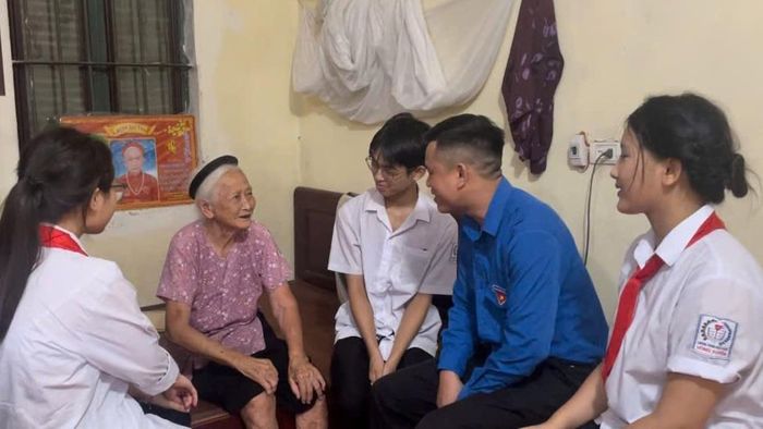 Đoàn viên, thanh niên trò chuyện với Mẹ Việt Nam Anh hùng Nguyễn Thị Năm (thôn Võng Ngoại). Ảnh: Cơ sở