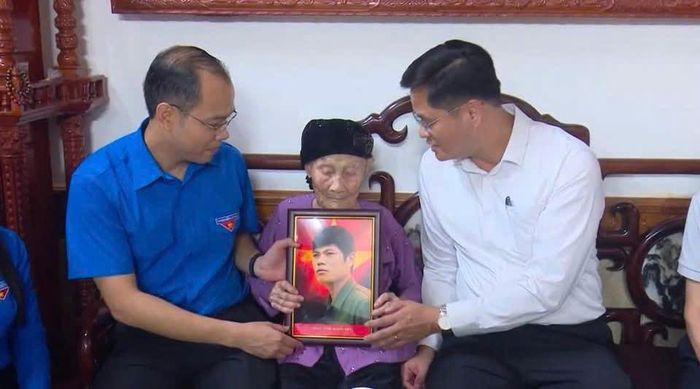 Phó Chủ tịch Ủy ban Mặt trận Tổ quốc Việt Nam thành phố, Bí thư Thành đoàn Hà Nội Nguyễn Tiến Hưng (trái) thăm hỏi, tặng quà tri ân và trực tiếp trao di ảnh cho gia đình Liệt sĩ Trần Quang Pha. Ảnh: Thành đoàn