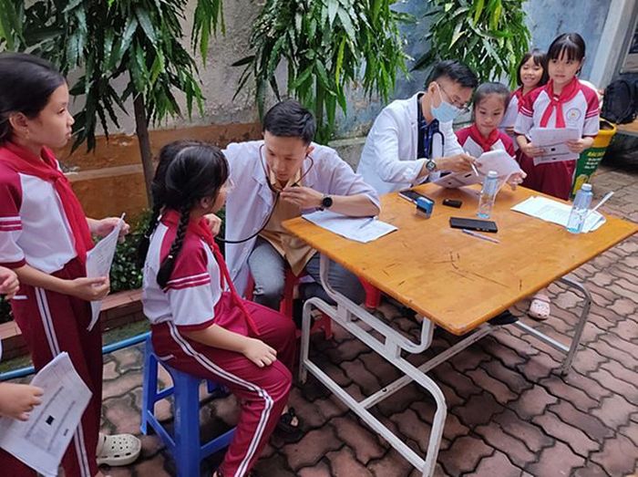 Bác sĩ Bệnh viện ĐKKV Hóc Môn khám sức khỏe cho học sinh tại trường học. Ảnh: BVCC.