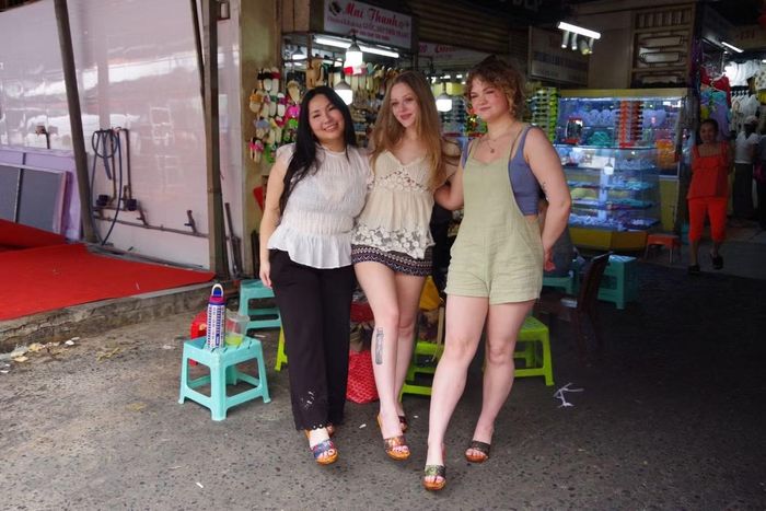 Nhóm du khách Katy - Sofie - Maggie "tậu" những đôi guốc ưng ý. Ảnh: Kim Cương