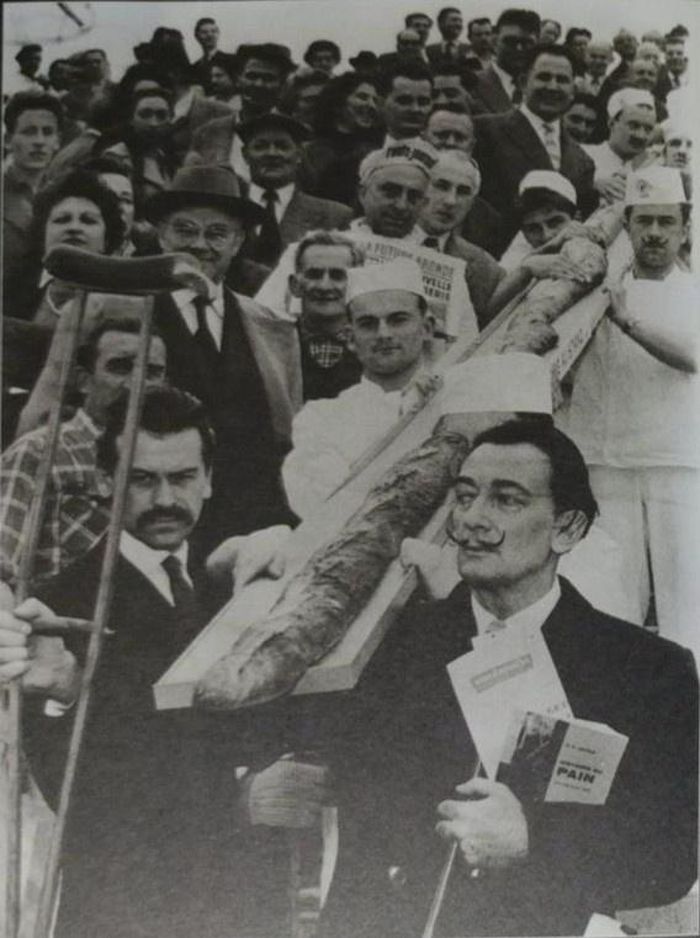  Dalí cùng với họa sĩ Georges Mathieu và ổ bánh mỳ baguette dài 12 mét, đang được 2 người đưa ra trình diễn tại Đấu xảo Paris (Foire de Paris) 13 tháng 5, 1958. Ảnh trong sách Đây là Dalí. 