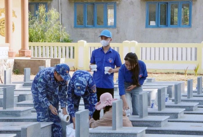 Chiến sĩ Hải đội 23 cùng lực lượng đoàn viên, thanh niên địa phương dọn vệ sinh tại Nghĩa trang Liệt sĩ Bình Đông, xã Vạn Tường