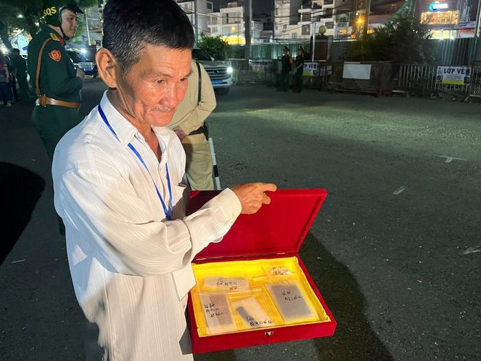 Ông Huỳnh Văn Nhỏ cầm trên tay những di vật của liệt sĩ Huỳnh Văn Quên
