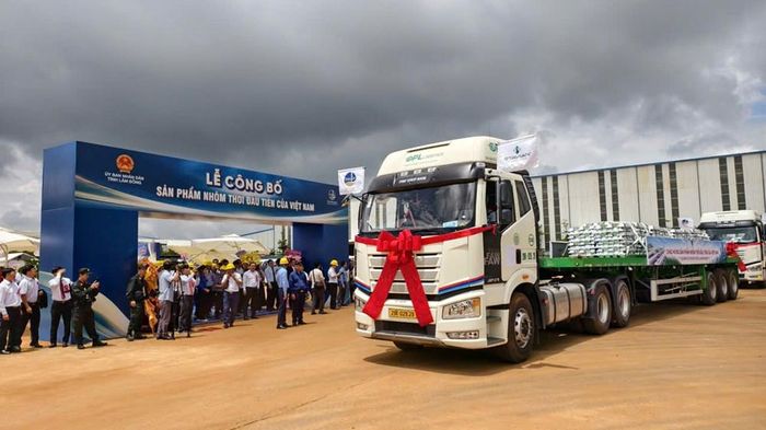 Những xe chở nhôm tinh luyện từ từ lăn bánh trước sự chứng kiến của các đại biểu