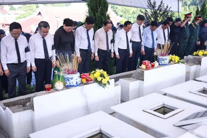 Các đại biểu thực hiện nghi thức mặc niệm, tiễn biệt các liệt sĩ. Ảnh: Hoàng Hiếu - TTXVN