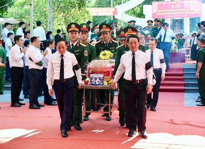 Trưởng Ban Tuyên giáo và Dân vận Trung ương Trịnh Văn Quyết cùng các đại biểu thực hiện nghi thức truy điệu và an táng các anh hùng liệt sĩ - Ảnh: VGP/Thu Sa