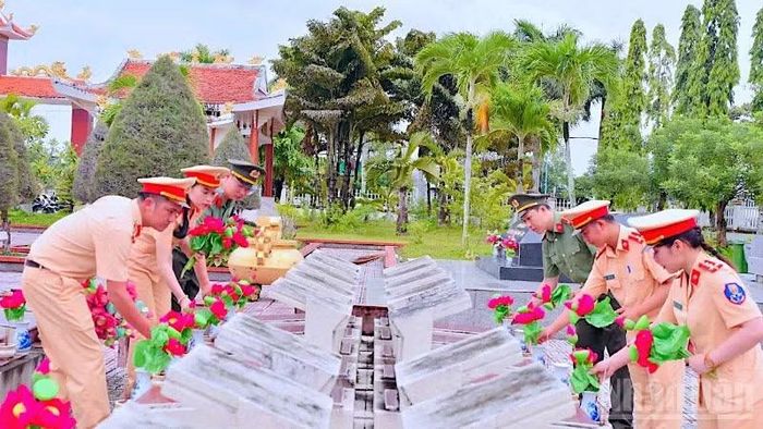 Cán bộ, chiến sĩ Công an Cà Mau chỉnh trang, dọn dẹp vệ sinh và thay mới hoa sen tại Nghĩa trang liệt sĩ tỉnh.