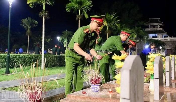 Đoàn viên thanh niên Công an tỉnh Điện Biên thắp nến, dâng hương trên từng phần mộ liệt sĩ trong Nghĩa trang Liệt sĩ A1.