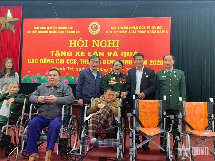 Đại diện lãnh đạo Công ty Cổ phần Dịch vụ-Thương mại xuất, nhập khẩu Nam Á trao xe lăn và quà tặng thương binh nặng trên địa bàn TP Hà Nội, tháng 3-2020. Ảnh do Công ty cung cấp 