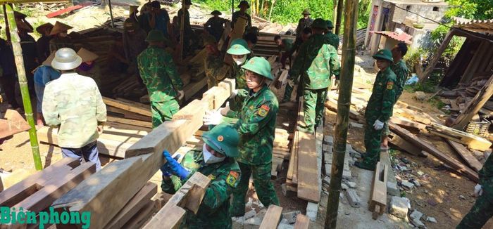 Cán bộ, chiến sĩ Trung tâm Huấn luyện - Cơ động Tây Bắc phối hợp cùng người dân tháo dỡ, vận chuyển các cấu kiện nhà ở đến nơi ở mới. Ảnh: Nghĩa Hà