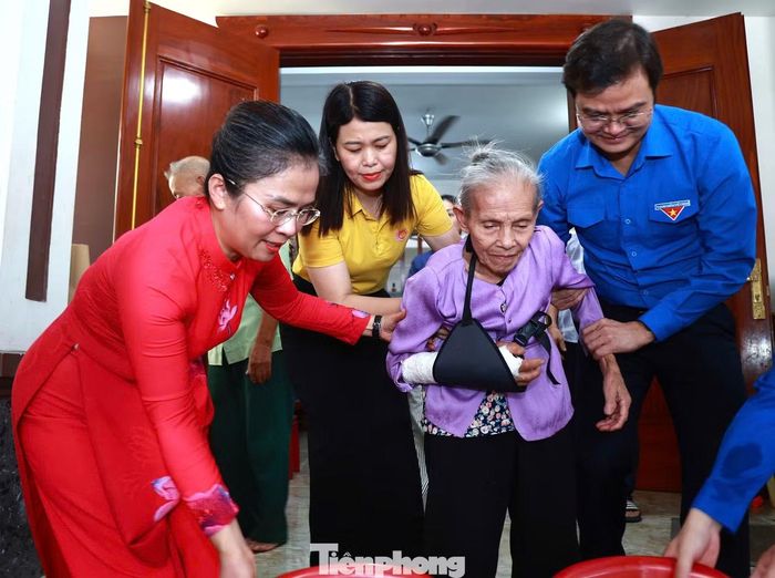 Anh Bùi Quang Huy - Ủy viên BCH T.Ư Đảng, Bí thư thứ nhất T.Ư Đoàn và bà Võ Thị Minh Sinh - Phó Bí thư Tỉnh ủy, Chủ tịch Ủy ban MTTQ Việt Nam tỉnh Nghệ An dìu cựu TNXP Trần Thị Thông.