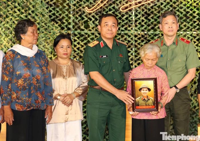 Bà Nguyễn Thị Lệ ôm hình ảnh liệt sĩ Huỳnh Văn Quên được phục dựng. Ảnh: Ngô Tùng