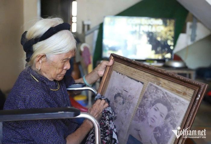 Mẹ Việt Nam Anh hùng Hoàng Thị Sinh nhẹ nhàng lau di ảnh hai người con