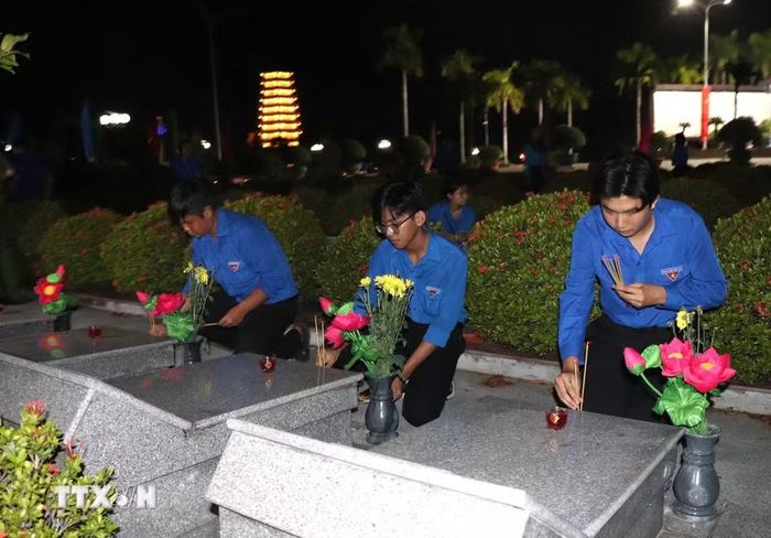 Đoàn viên, thanh niên dâng hương tại các phần mộ liệt sỹ ở Nghĩa trang liệt sỹ Vĩnh Long. (Ảnh: Lê Thúy Hằng/TTXVN).