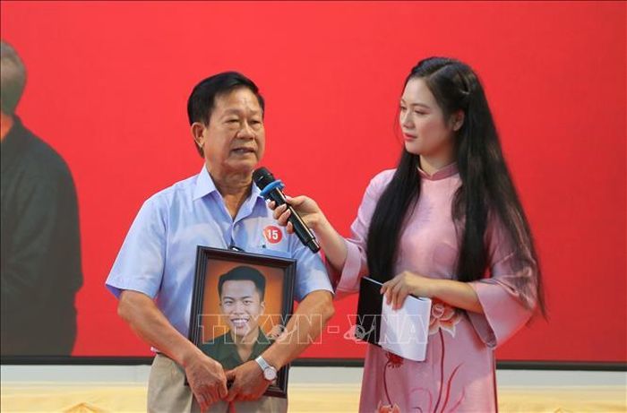 Đại diện gia đình đón nhận di ảnh Liệt sĩ Vũ Minh Xuân, hy sinh năm 1970. Ảnh: Minh Thu/TTXVN