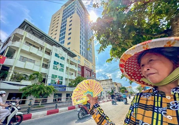 Người bán vé số dạo trên đường Cách Mạng Tháng Tám, phía sau là trụ sở Công ty Xổ số kiến thiết Cần Thơ. Ảnh minh họa: Thanh Liêm/TTXVN