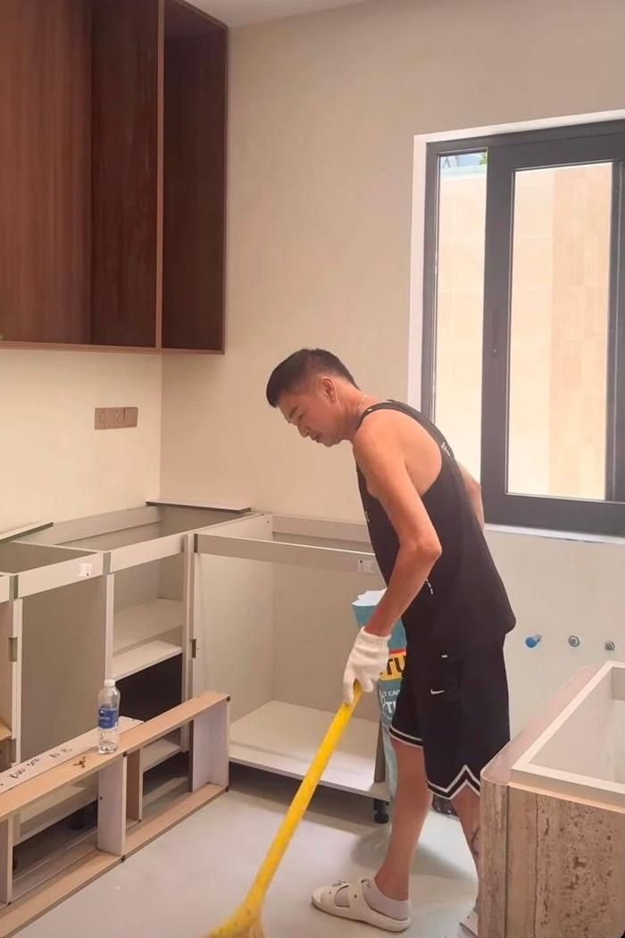 Nghệ sĩ Quang Minh dọn dẹp căn nhà đang dần hoàn thiện.