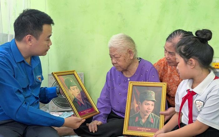 Mẹ Việt Nam Anh hùng Nguyễn Thị Kim xúc động đón nhận ảnh phục dựng của 2 liệt sĩ do Tỉnh đoàn Lạng Sơn trao tặng.