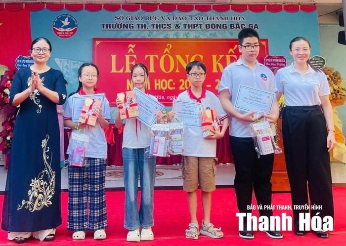 Cô giáo Lê Thị Bích trao học bổng tiếng Anh cho các em học sinh Trường Tiểu học, THCS& THPT Đông Bắc Ga.