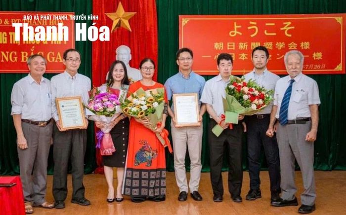 Thầy giáo Lê Bật Liêm (ngoài cùng bên trái) và cô giáo Lê Thị Bích (ở giữa) chụp ảnh lưu niệm cùng đại diện Hội khuyến học Báo Asahi Tokyo.