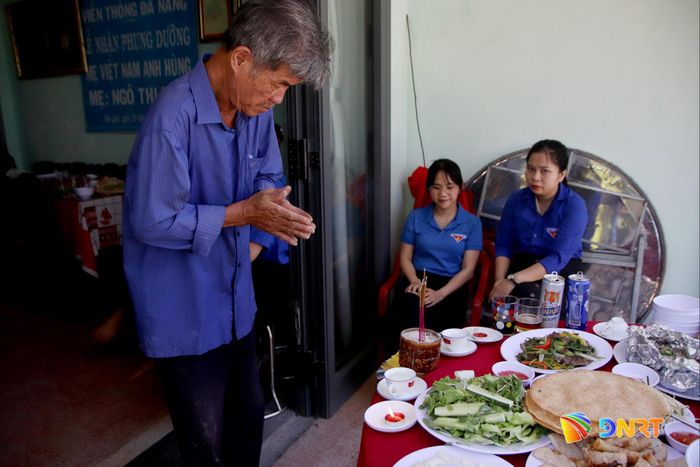 Con trai mẹ Tính khấn vái hương hồn cha và chị gái là liệt sĩ tại bữa cơm tri ân của Đoàn phường. Ảnh: HÀN NGUYÊN
