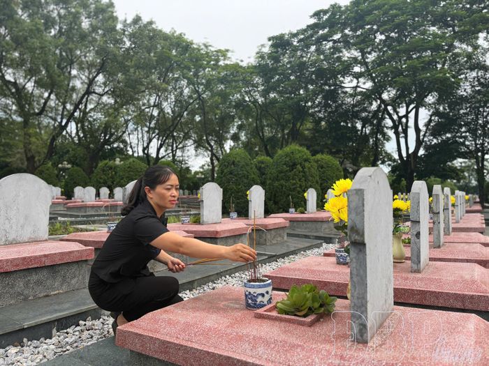 Chị Vũ Thị Thu Hà thắp hương tại các phần mộ liệt sĩ.