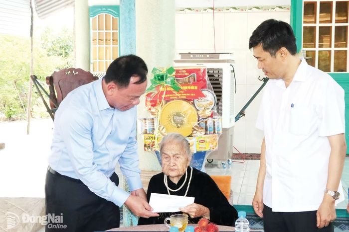 Phó Bí thư Thành ủy Võ Tấn Đức thăm, tặng quà Mẹ Việt Nam anh hùng Nguyễn Thị Ngừng, sinh năm 1925, phường Chơn Thành. Ảnh: Quang Minh