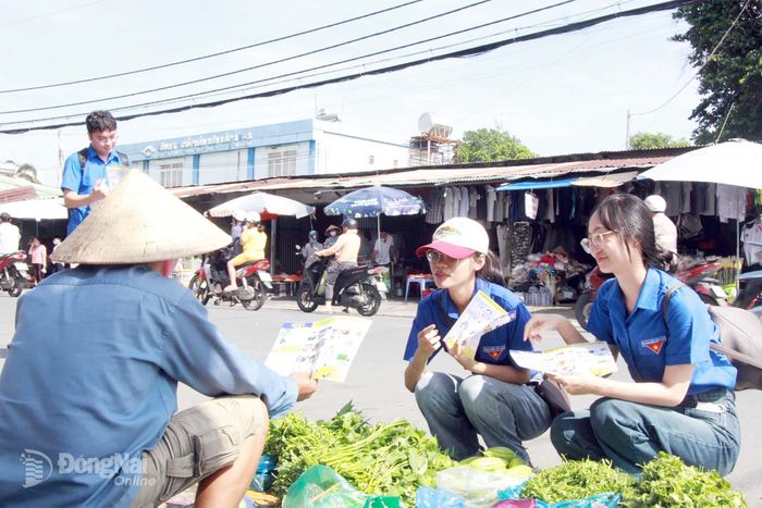 Đoàn viên, thanh niên tuyên truyền, vận động người dân tham gia phân loại chất thải rắn sinh hoạt tại nguồn. Ảnh: Nga Sơn
