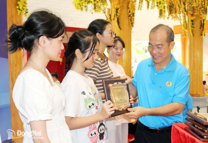 Chủ tịch Công đoàn cơ sở Công ty cổ phần TKG Taekwang Vina Đinh Sỹ Phúc trao khen thưởng cho các em học sinh. Ảnh: Nguyễn Hòa