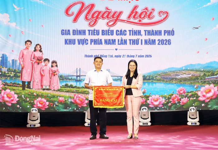 Thành ủy viên, Giám đốc Sở Văn hóa, Thể thao và Du lịch Lê Thị Ngọc Loan trao cờ đăng cai ngày hội năm 2027 cho tỉnh Vĩnh Long. Ảnh: My Ny