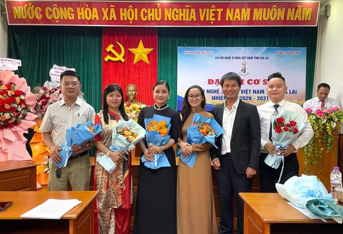  Nghệ sĩ Ưu tú Đặng Công Hưng tặng hoa chúc mừng Ban Chấp hành Chi hội nhiệm kỳ 2026 - 2031. Nghệ sĩ Kim Tiển đứng thứ 3 từ trái sang. Ảnh: Lam Nguyên 