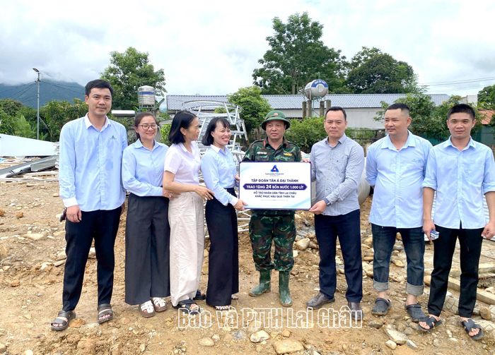 Đại diện Tập đoàn Tân Á Đại Thành cũng trao biển tượng trưng bồn chứa nước cho xã Mường Than giúp các hộ tái định cư.