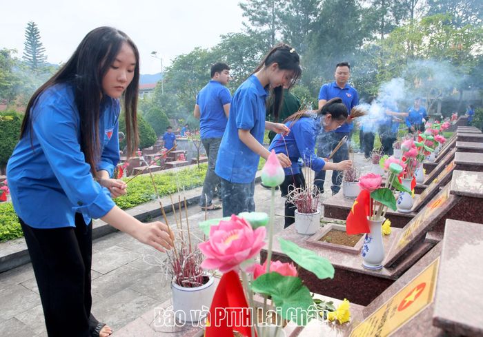 Các đại biểu, đoàn viên, nhân dân thắp hương mộ phần liệt sĩ. 